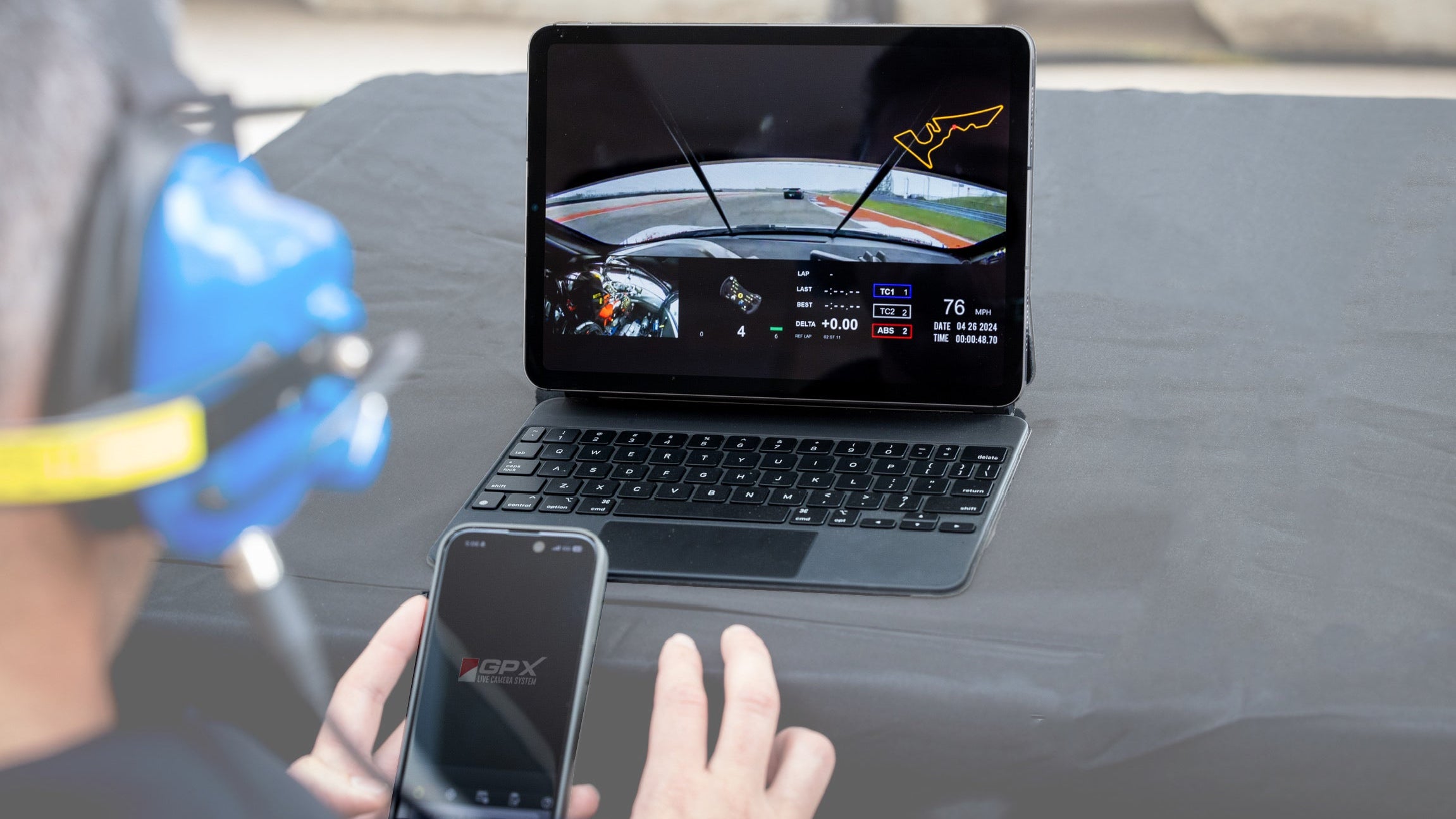 Person using a GPX Mobile live onboard, holding a smartphone with a visible brand logo.